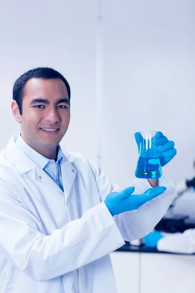 Estudiante de ciencias sosteniendo química azul en vaso de precipitados —  Fotos de Stock