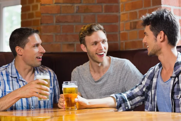 Feliz amigos brindar com pints de cerveja — Fotografia de Stock
