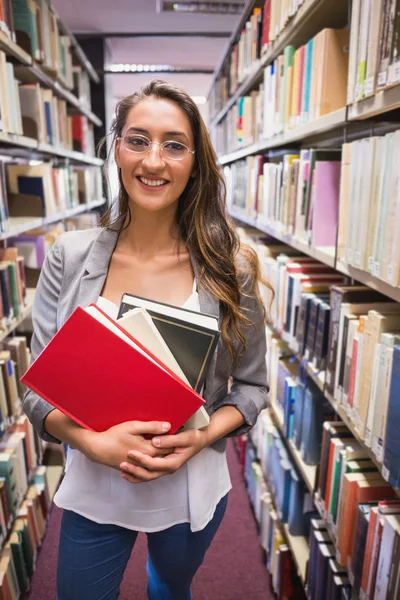 Estudante bonito escolhendo um livro na biblioteca — Fotografia de Stock