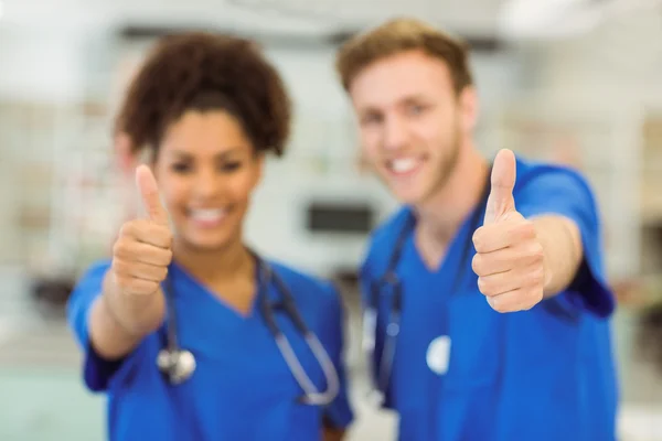 Jóvenes estudiantes de medicina mostrando pulgares hacia arriba —  Fotos de Stock