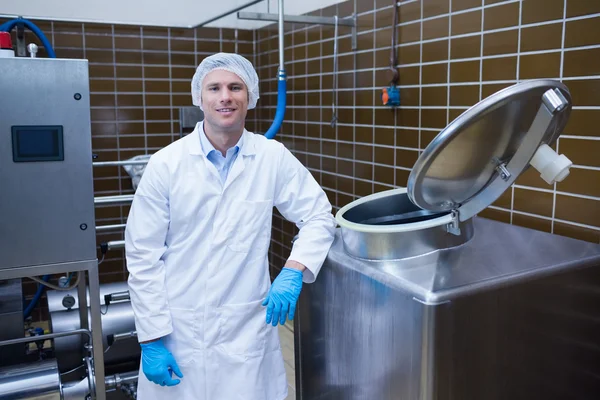 Smiling biologist leaning against storage tank — Stock Photo, Image