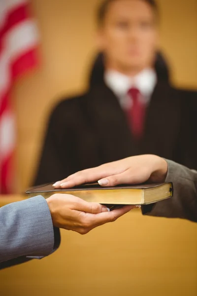 Witness swearing on the bible telling the truth — Stock Photo, Image