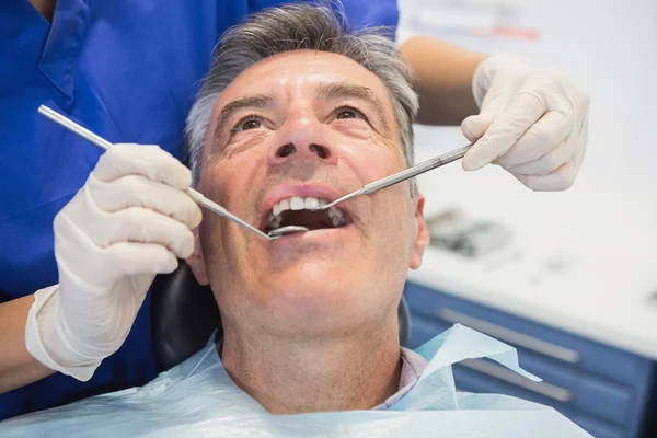 Dentysta bada pacjenta z narzędzia — Zdjęcie stockowe