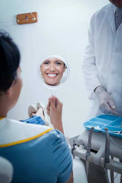 Smiling young woman looking at mirror — Stock Photo, Image
