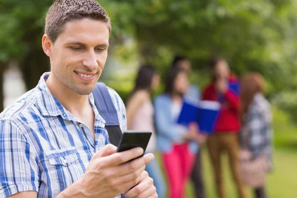 Happy student sending a text outside on campus — Stock Photo, Image