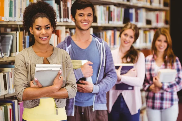 Happy students holding books in row — Stock Photo, Image