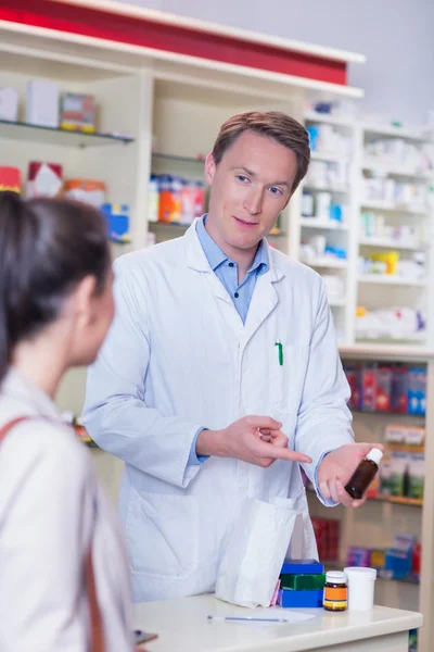 Farmacista che indica una fiaschetta di pillole — Foto Stock