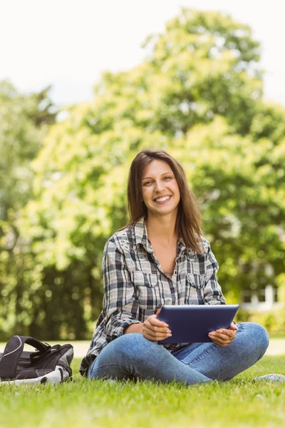 Glimlachend student zitten en de tablet pc gebruiken — Stockfoto