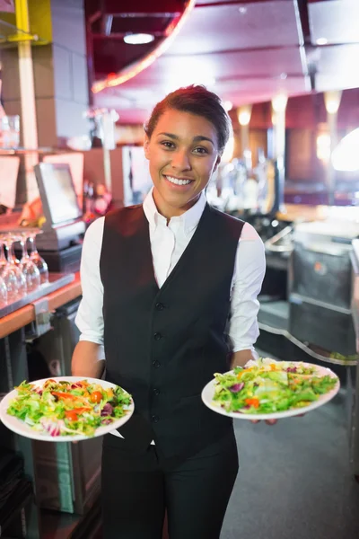 Salata tabakları tutan güzel barmen — Stok fotoğraf