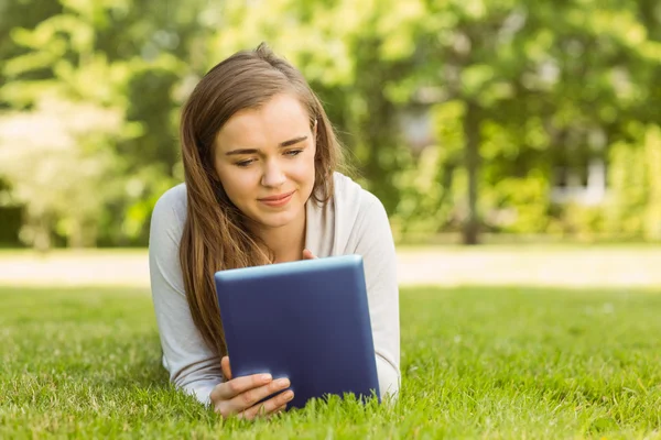 Studentka leżącego i przy użyciu komputera typu tablet — Zdjęcie stockowe