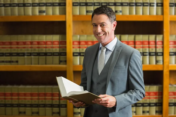 Ügyvéd gazdaság könyv a törvény könyvtárban — Stock Fotó