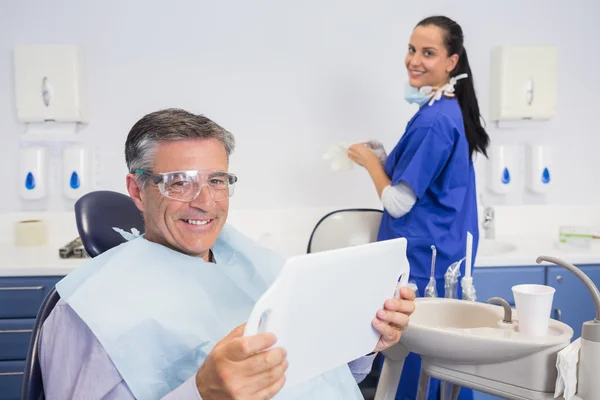 Sonriente paciente sosteniendo un espejo — Foto de Stock