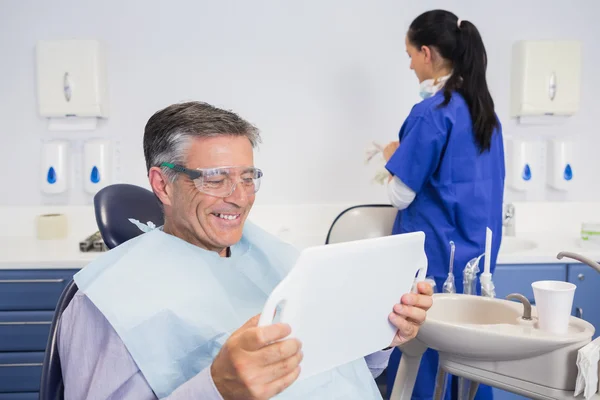 Sonriente paciente sosteniendo un espejo — Foto de Stock