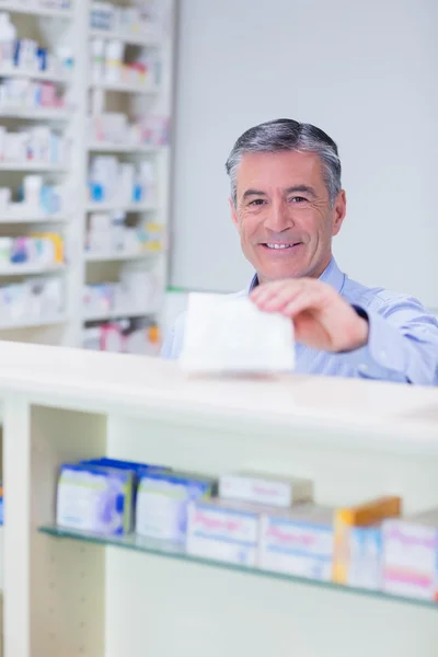 Pharmacist with grey hair holding a prescription — Stock Photo, Image