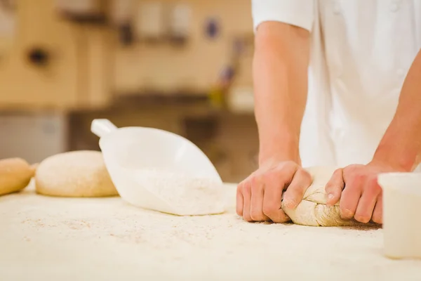 Baker amassando a massa de farinha em um balcão — Fotografia de Stock