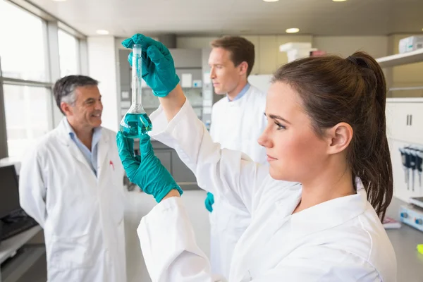 Junge Wissenschaftlerin hält Reagenzglas hoch — Stockfoto