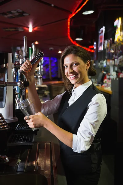 Barmaid feliz puxando uma caneca de cerveja — Fotografia de Stock