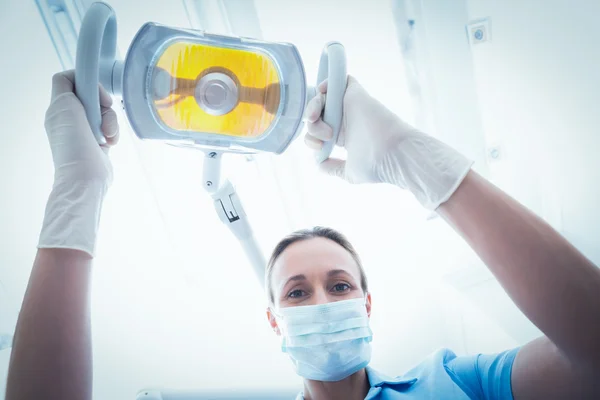Dentiste femme ajustant la lumière — Photo