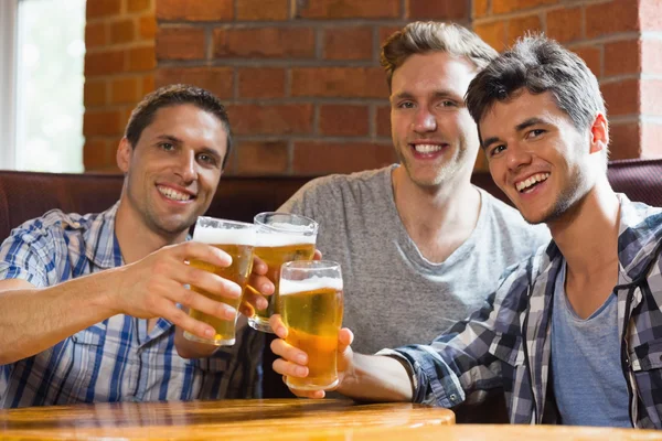 Feliz amigos brindar com pints de cerveja — Fotografia de Stock
