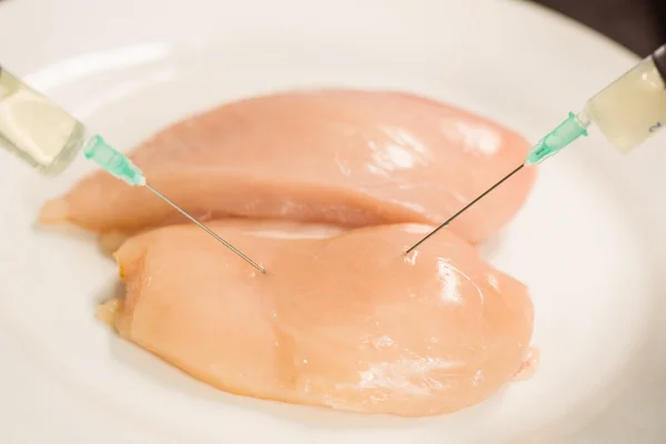 Food scientist injecting raw chicken — Stock Photo, Image