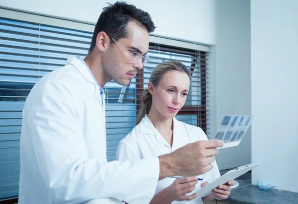 Dentists looking at x-ray — Stock Photo, Image