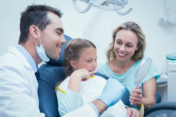 Dentist examining girls teeth with assistant — Stock Photo, Image