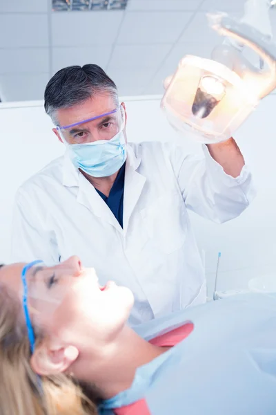 Dentista examinando los dientes de un paciente — Foto de Stock