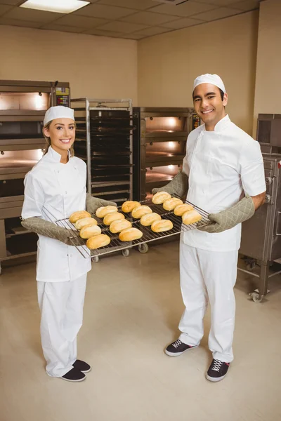 Bäckerteam hält Regal mit Brötchen — Stockfoto