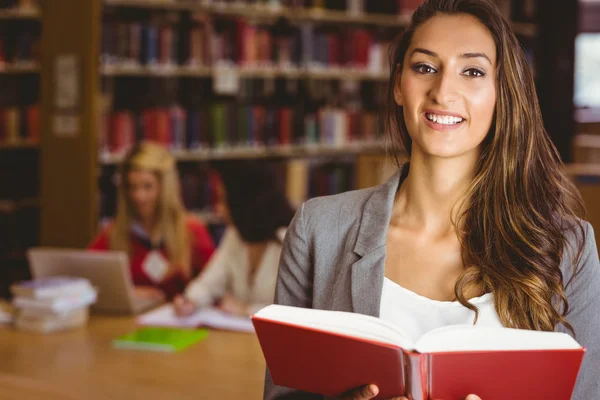 Studente sorridente che tiene un libro — Foto Stock