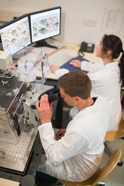 Estudiantes de bioquímica usando microscopio grande — Foto de Stock