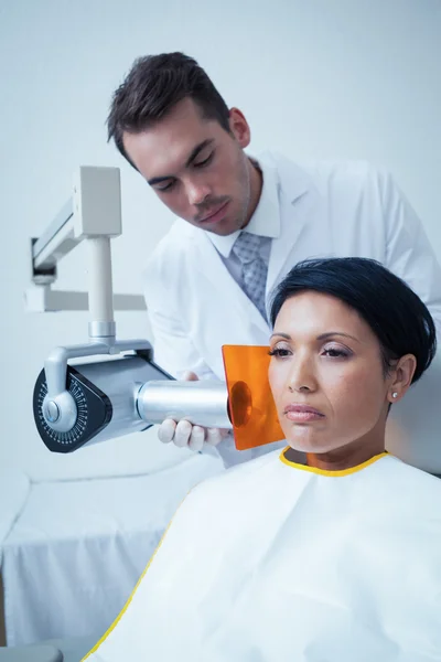 Серьёзная молодая женщина проходит стоматологическое обследование — стоковое фото