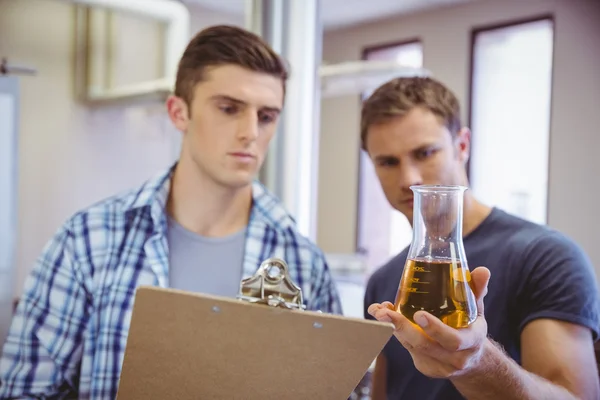 Dos hombres mirando el vaso con cerveza — Foto de Stock