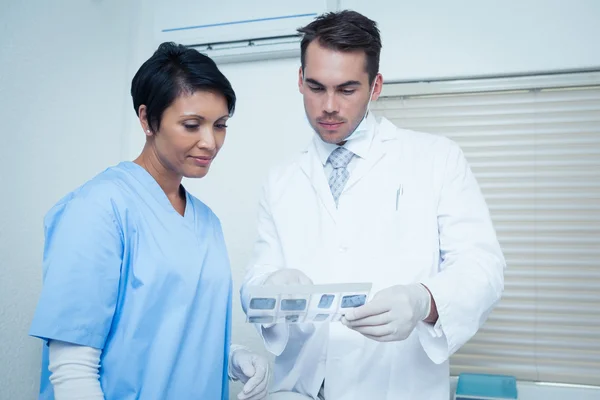 Dentists looking at x-ray — Stock Photo, Image