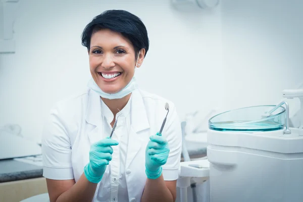 Dentista feliz feminino segurando ferramentas dentárias — Fotografia de Stock