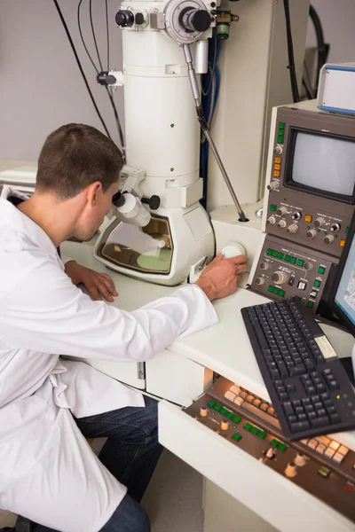 Estudante de bioquímica usando microscópio grande e computador — Fotografia de Stock