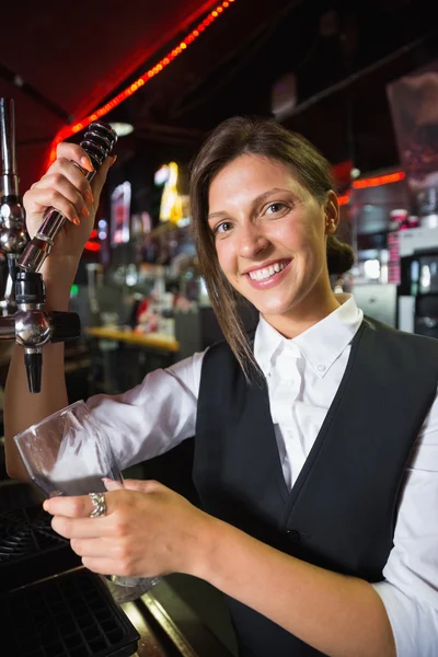 Feliz camarera sacando una pinta de cerveza — Foto de Stock
