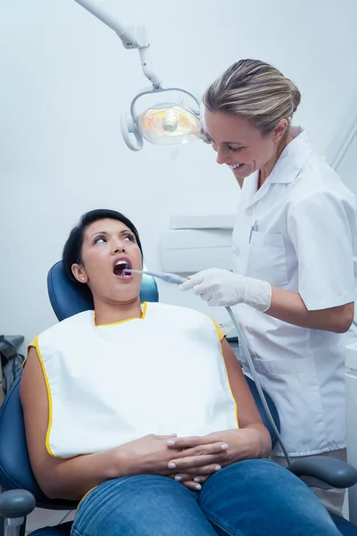 Dentista feminina examinando os dentes das mulheres — Fotografia de Stock