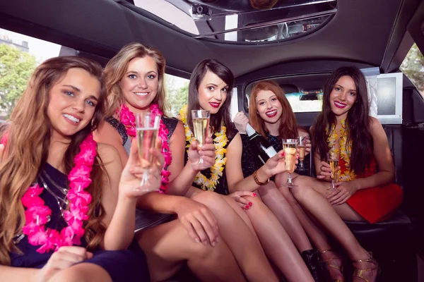 Happy vrienden drinken champagne in limousine — Stockfoto