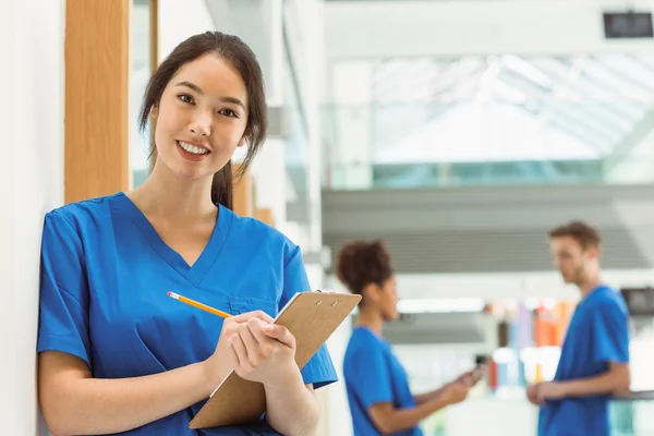 Läkarstuderande göra anteckningar i korridoren — Stockfoto