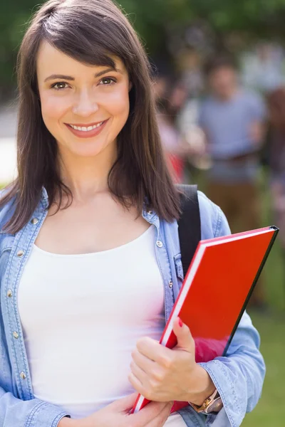 Pretty student smiling at camera outside on campus — Stock Photo, Image