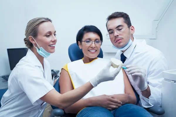 Dentists showing woman prosthesis teeth — Stock Photo, Image