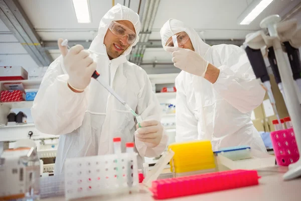 Science students working in protective suits — Stock Photo, Image