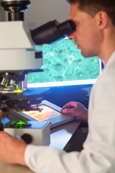 Estudante de ciência olhando através do microscópio — Fotografia de Stock