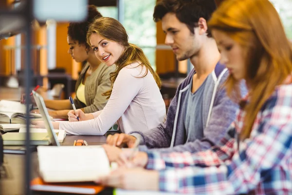 Student söker på kameran medan du studerar med klasskamrater — Stockfoto