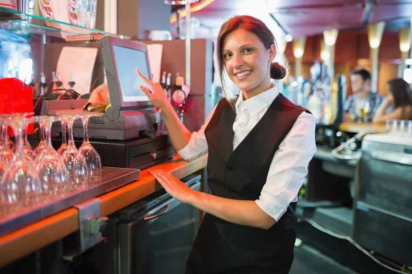 Happy barmanka pomocí dotykové obrazovky až do — Stock fotografie