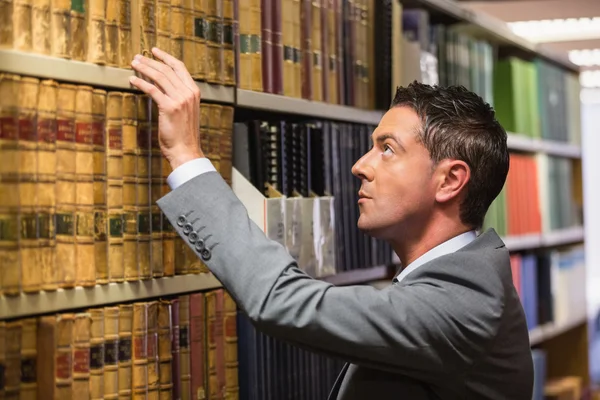 Advogado escolher livro na biblioteca de direito — Fotografia de Stock