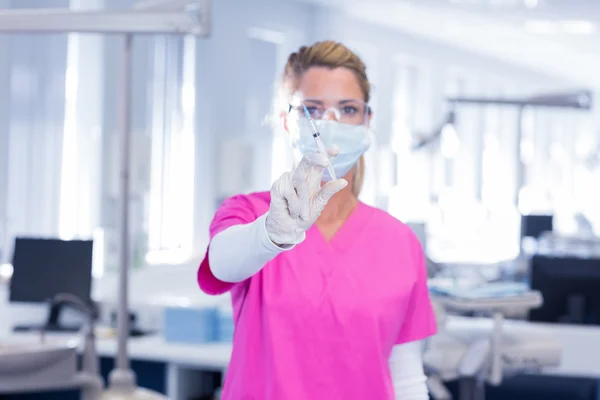 Οδοντίατρος σε χειρουργική μάσκα και τρίβει κρατώντας syring — Φωτογραφία Αρχείου