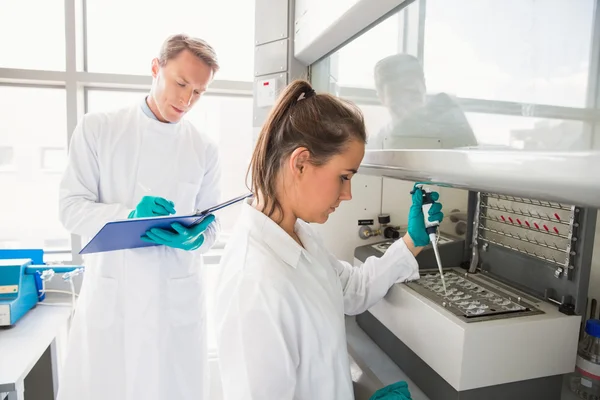 Junge Wissenschaftlerin mit Pipette in der Kammer — Stockfoto