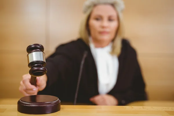 Серьезный судья с молотком в халатах и парике — стоковое фото