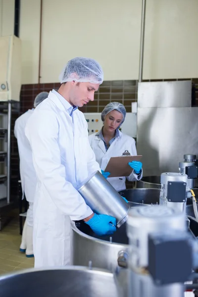 Scheikundige team samen te werken terwijl het meisje schrijven — Stockfoto